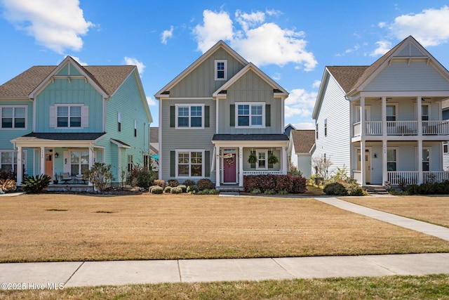 craftsman inspired home featuring board and batten siding, ceiling fan, a front lawn, and covered porch