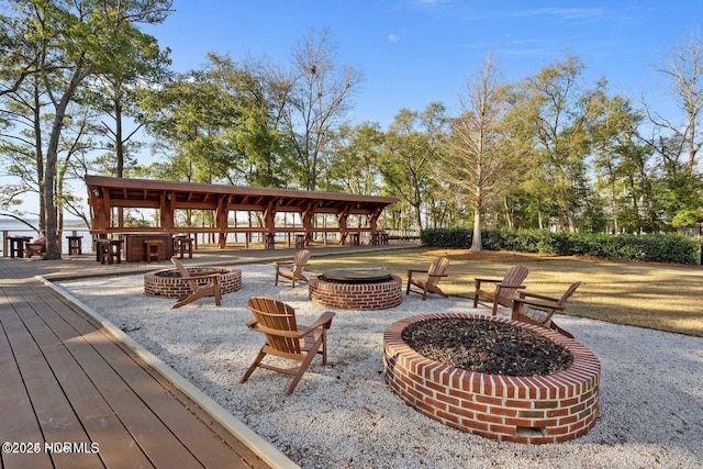view of property's community with a wooden deck and an outdoor fire pit