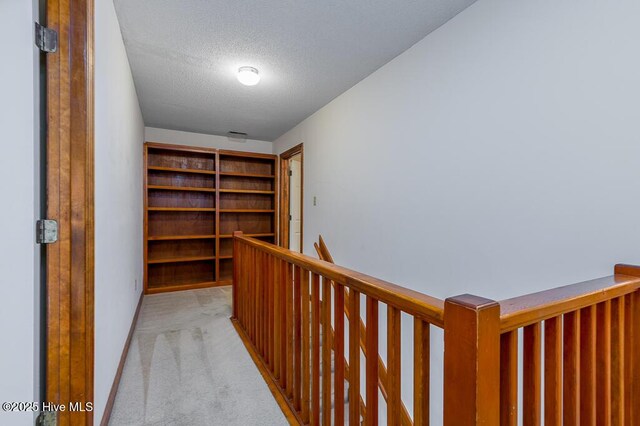 138 Stonebridge Trl, Havelock, NC 28532 - hall featuring a textured ceiling, light carpet, an upstairs landing, and baseboards
