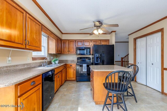 138 Stonebridge Trl, Havelock, NC 28532 - kitchen featuring a sink, brown cabinets, black appliances, crown molding, and a kitchen island