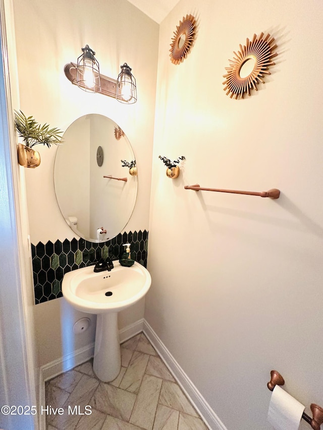 bathroom with baseboards, a sink, and marble finish floor