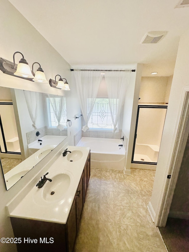 bathroom featuring visible vents, a sink, a bath, and a shower stall