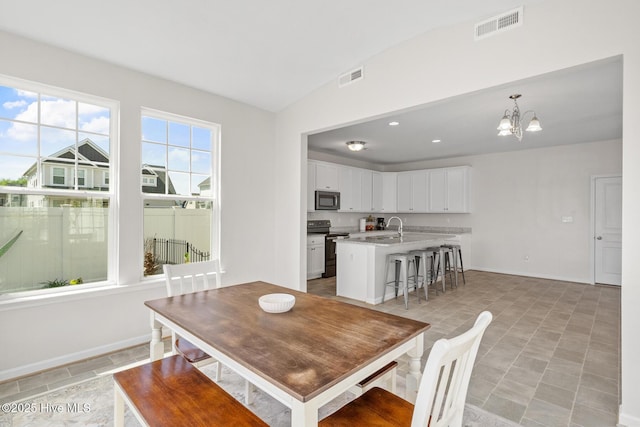 dining area with baseboards, a notable chandelier, vaulted ceiling, and visible vents