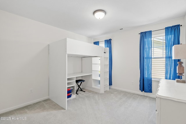 unfurnished bedroom with light carpet, visible vents, and baseboards