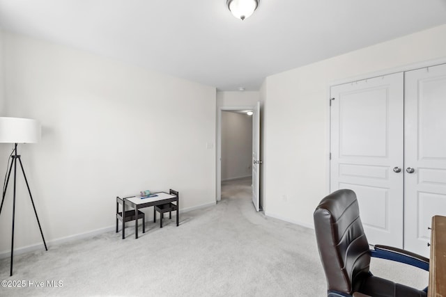 office with baseboards and light carpet