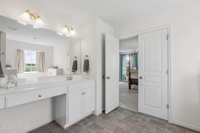 bathroom featuring plenty of natural light, vanity, visible vents, and connected bathroom