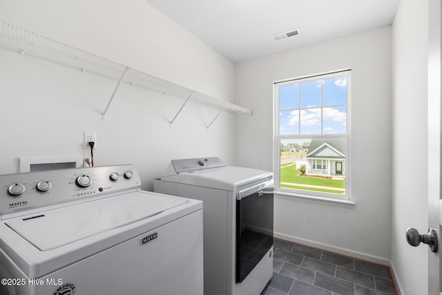laundry room with laundry area, independent washer and dryer, dark tile patterned flooring, visible vents, and baseboards