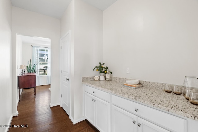 interior space with baseboards and dark wood-style floors