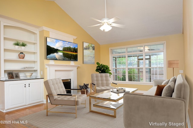 995 Monticello Dr, Pinehurst, NC 28374 - living room featuring light wood-style floors, a ceiling fan, a glass covered fireplace, baseboards, and high vaulted ceiling
