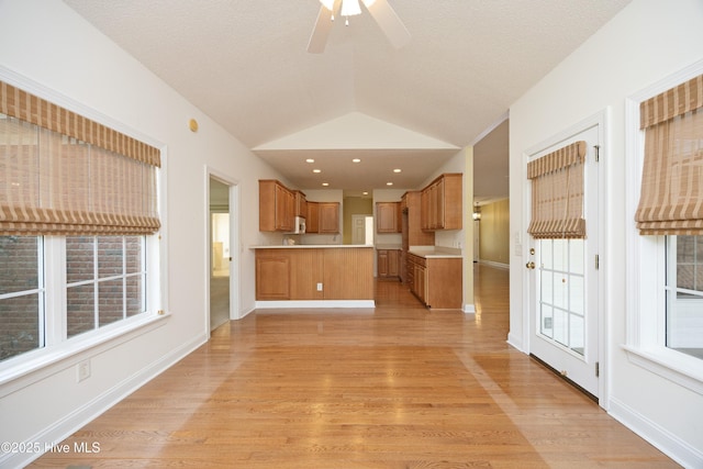 995 Monticello Dr, Pinehurst, NC 28374 - unfurnished living room featuring healthy amount of natural light, light wood-type flooring, a ceiling fan, and vaulted ceiling