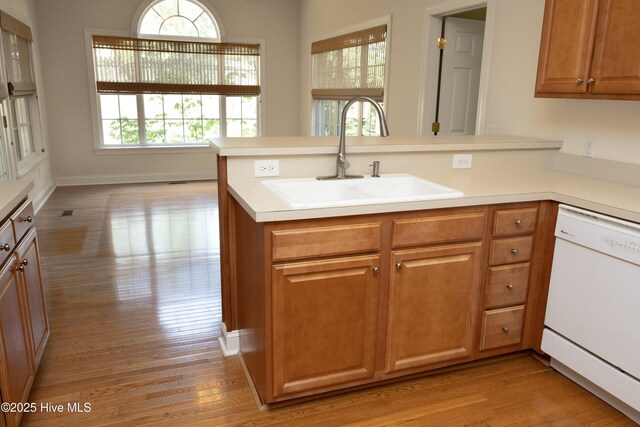 995 Monticello Dr, Pinehurst, NC 28374 - kitchen featuring white dishwasher, a sink, a peninsula, light wood-type flooring, and light countertops