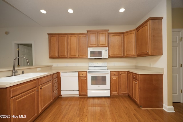 995 Monticello Dr, Pinehurst, NC 28374 - kitchen with white appliances, a sink, a peninsula, light wood-type flooring, and recessed lighting