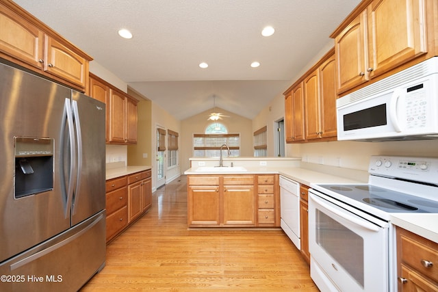 995 Monticello Dr, Pinehurst, NC 28374 - kitchen with white appliances, a sink, a peninsula, vaulted ceiling, and light countertops