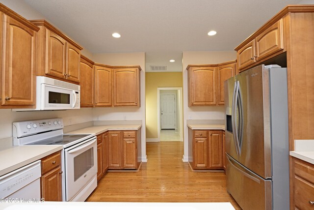 995 Monticello Dr, Pinehurst, NC 28374 - kitchen with white appliances, light wood-type flooring, baseboards, recessed lighting, and light countertops