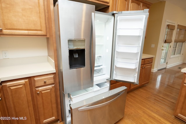 995 Monticello Dr, Pinehurst, NC 28374 - kitchen with light wood finished floors, light countertops, and brown cabinetry