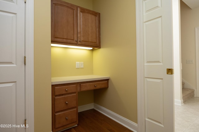 995 Monticello Dr, Pinehurst, NC 28374 - unfurnished office featuring built in desk, baseboards, and dark wood-type flooring