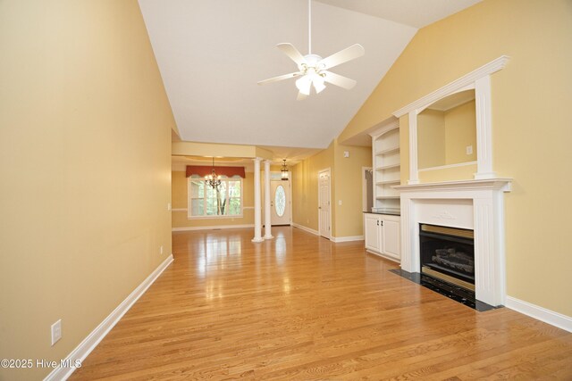 995 Monticello Dr, Pinehurst, NC 28374 - unfurnished living room with a chandelier, light wood-type flooring, vaulted ceiling, a ceiling fan, and a fireplace with flush hearth