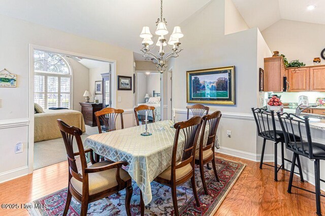 105 W Chelsea Ct, Southern Pines, NC 28387 - dining space featuring light wood-style flooring, a notable chandelier, baseboards, and lofted ceiling