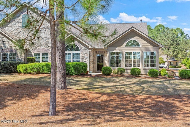 105 W Chelsea Ct, Southern Pines, NC 28387 - view of front of home featuring a sunroom, a shingled roof, and stone siding