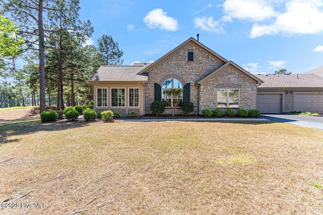 105 W Chelsea Ct, Southern Pines, NC 28387 - french provincial home with a front yard, stone siding, a garage, and concrete driveway