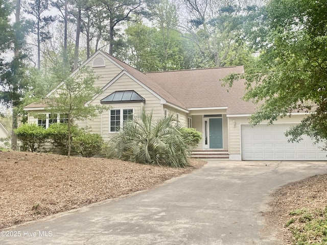 ranch-style house with driveway, a shingled roof, and a garage