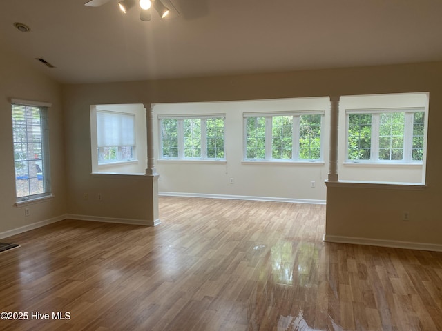 spare room featuring baseboards, wood finished floors, and visible vents