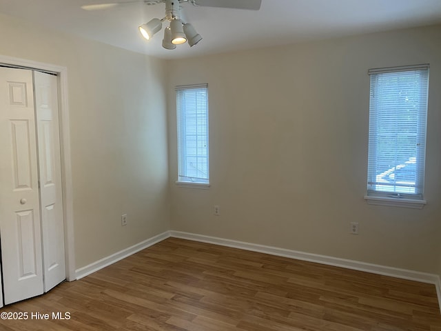 interior space featuring a ceiling fan, baseboards, and wood finished floors