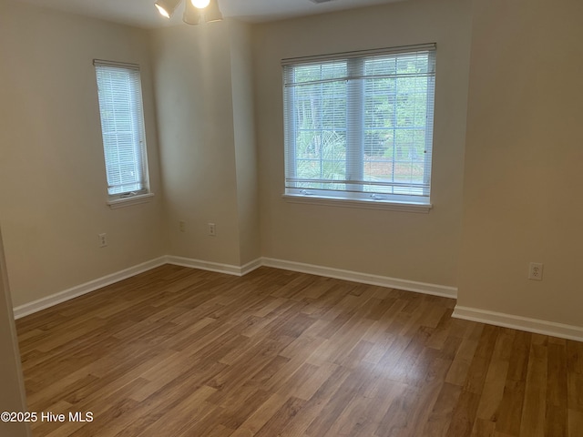 empty room featuring baseboards and light wood-style flooring