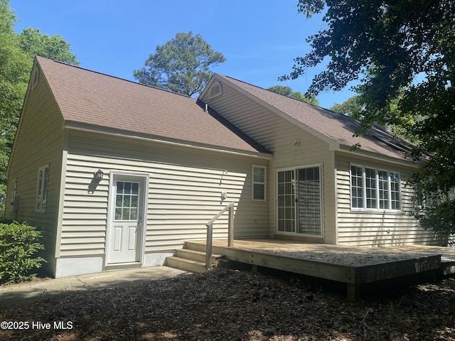 rear view of house with a wooden deck and a shingled roof
