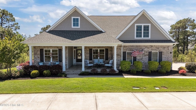 8549 Oak Abbey Trl NE, Leland, NC 28451 - craftsman house featuring french doors, roof with shingles, a front lawn, and covered porch