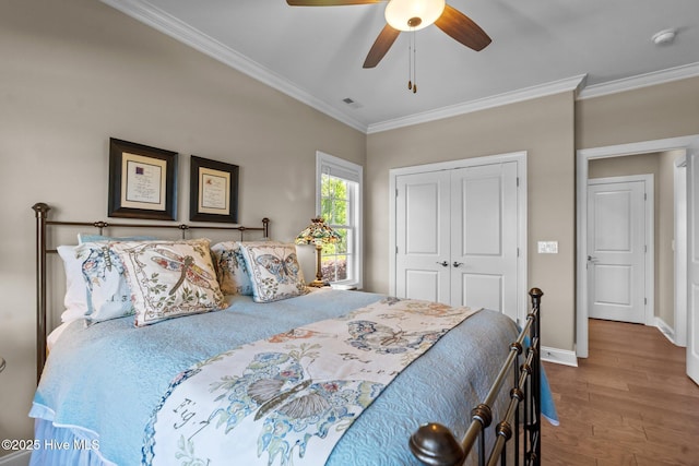 8549 Oak Abbey Trl NE, Leland, NC 28451 - bedroom with visible vents, baseboards, wood finished floors, a closet, and crown molding