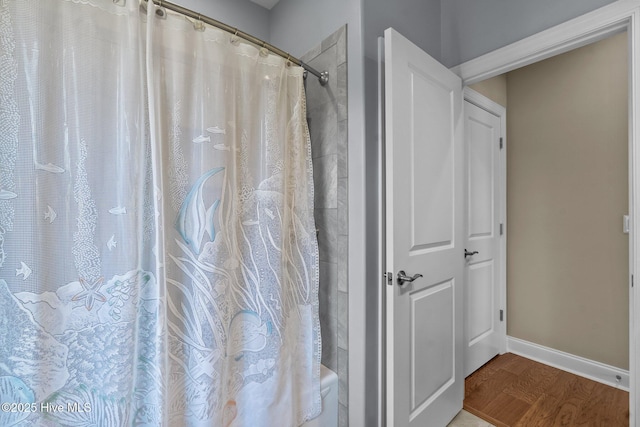 8549 Oak Abbey Trl NE, Leland, NC 28451 - bathroom with baseboards, wood finished floors, and curtained shower