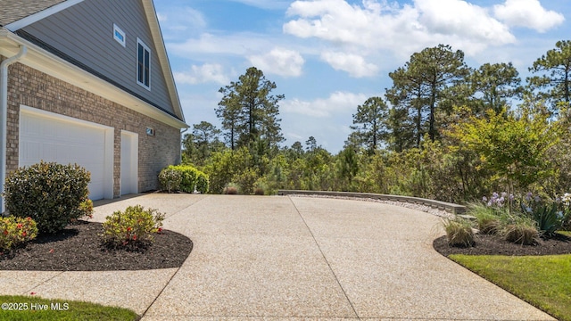 8549 Oak Abbey Trl NE, Leland, NC 28451 - view of patio featuring concrete driveway and a garage