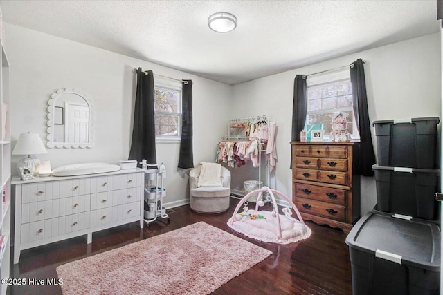 bedroom featuring a textured ceiling, wood finished floors, and baseboards