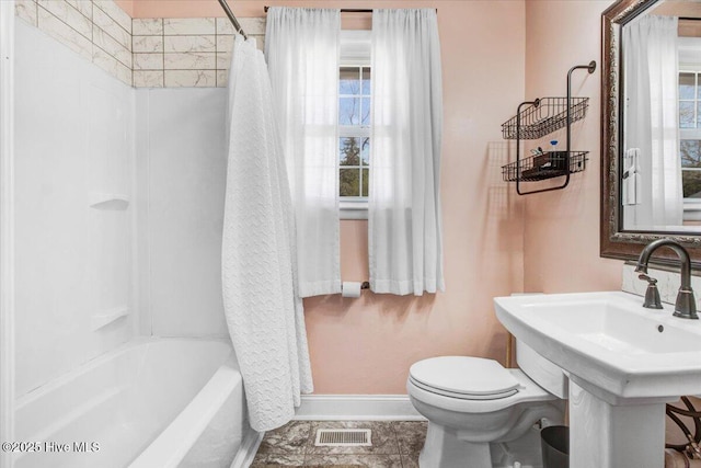 bathroom featuring shower / bath combo, visible vents, toilet, and baseboards
