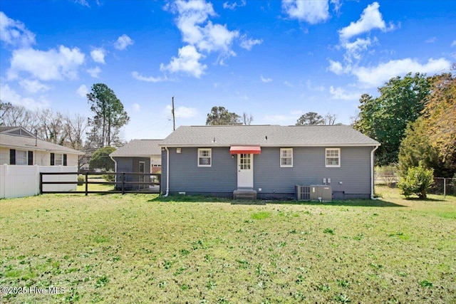 rear view of house with central air condition unit, entry steps, a yard, and a fenced backyard