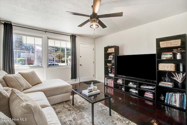 living area featuring baseboards, a textured ceiling, a ceiling fan, and wood finished floors