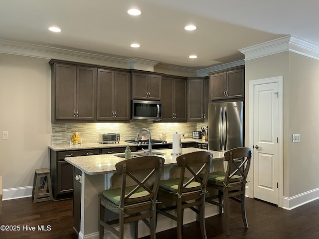 kitchen with crown molding, baseboards, stainless steel appliances, and dark brown cabinets