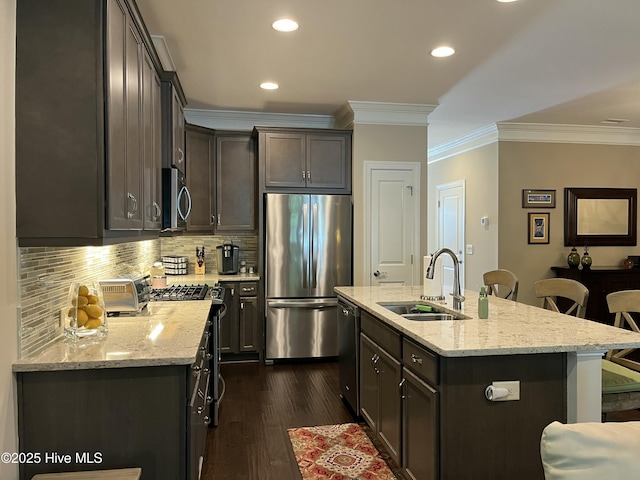 kitchen featuring decorative backsplash, a kitchen breakfast bar, crown molding, a sink, and stainless steel appliances