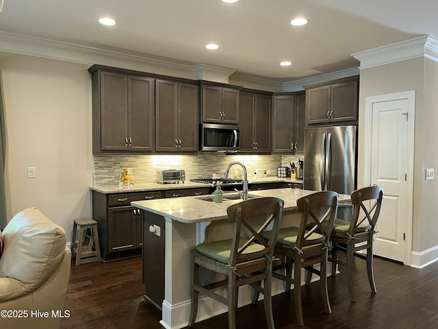 kitchen with ornamental molding, dark brown cabinetry, stainless steel appliances, and dark wood-type flooring
