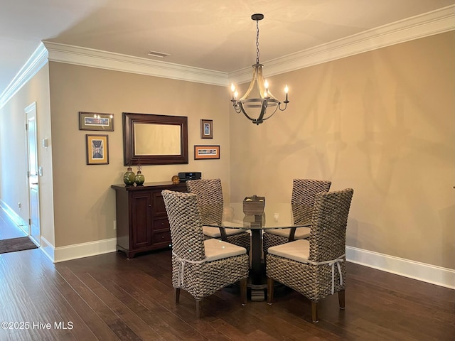 dining space featuring crown molding, dark wood finished floors, baseboards, and a chandelier
