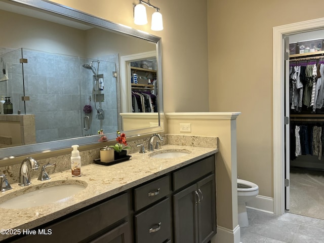 full bath with double vanity, toilet, a shower stall, and a sink