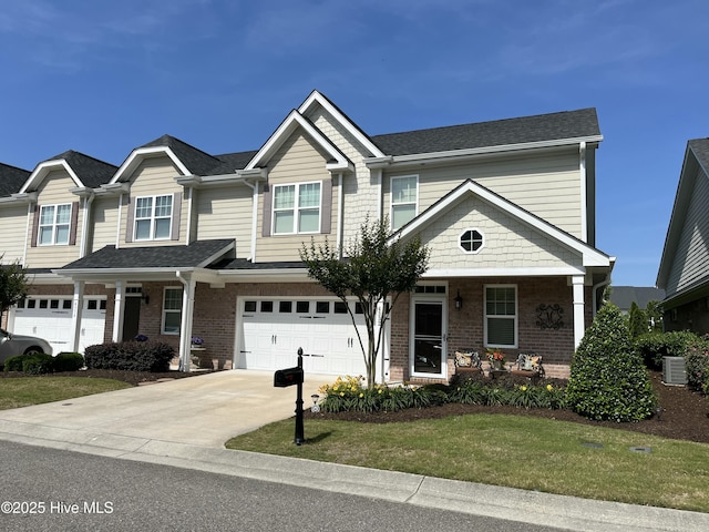 view of front of house with covered porch, brick siding, an attached garage, and driveway