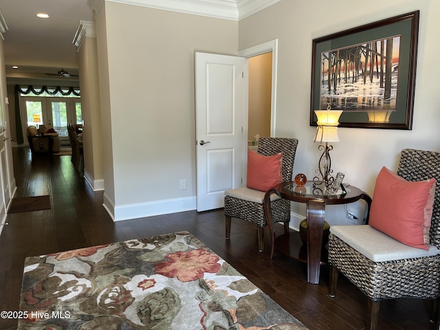 sitting room featuring wood-type flooring, recessed lighting, baseboards, and crown molding