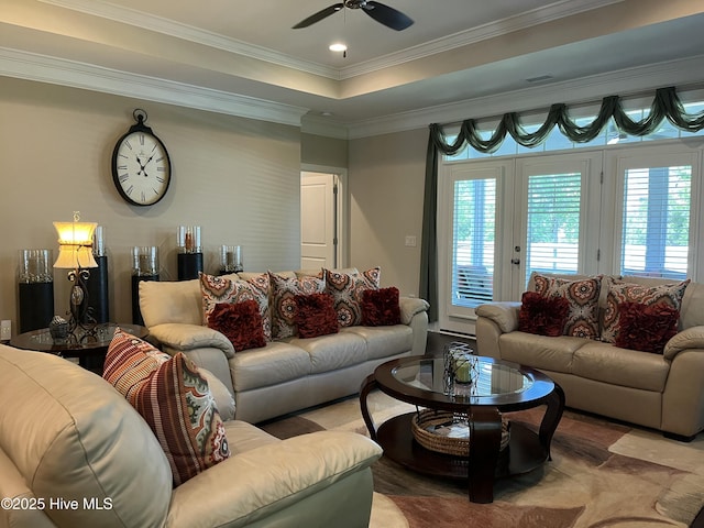 living room featuring plenty of natural light, a raised ceiling, ceiling fan, and ornamental molding