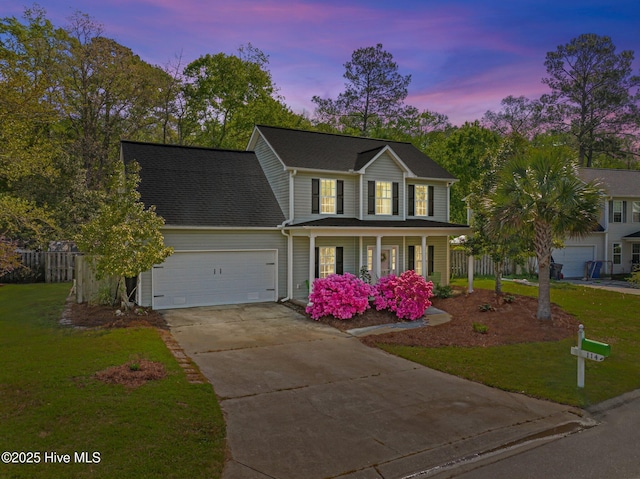 colonial inspired home with a garage, a front yard, driveway, and covered porch