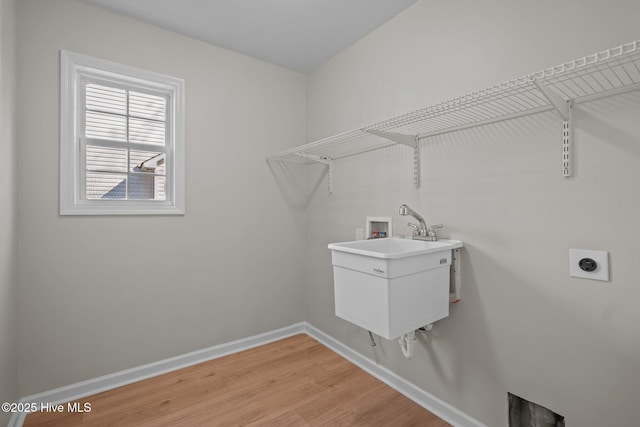 laundry room with washer hookup, a sink, laundry area, light wood finished floors, and electric dryer hookup