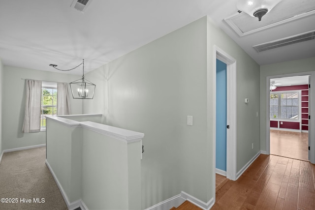 hallway featuring visible vents, an upstairs landing, and plenty of natural light