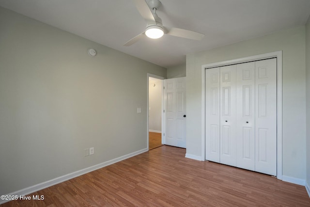 unfurnished bedroom featuring wood finished floors, ceiling fan, baseboards, and a closet