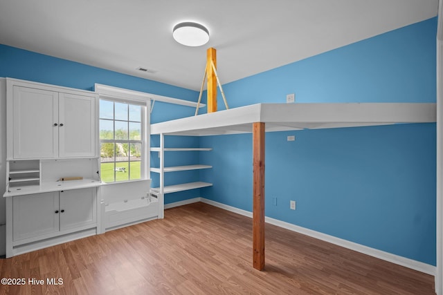 unfurnished bedroom featuring visible vents, baseboards, and light wood finished floors